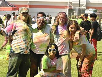 5 students posing together, covered in color.