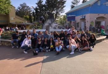 students posing seated outside